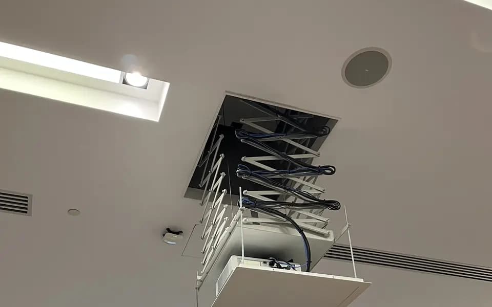 Vidéoprojecteur rétractable installé au plafond d'une salle de conférence